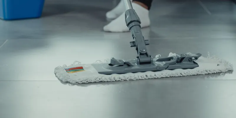 Flacher Wischmopp auf einem hellen Fliesenboden